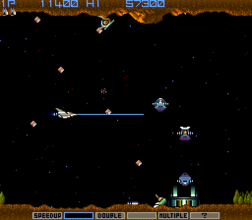 Gradius Arcade Screenshot: That structure on the ground releases new enemies until you destroy it.